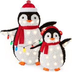 two stuffed penguins with christmas lights on them