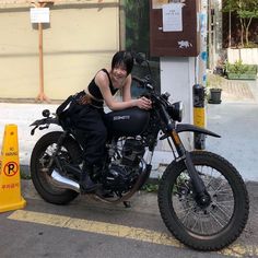 a woman sitting on the back of a motorcycle