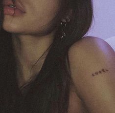 a close up of a person with a tattoo on her arm and shoulder, looking to the side