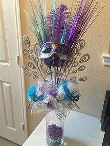 a vase filled with purple and blue feathers on top of a counter next to a door