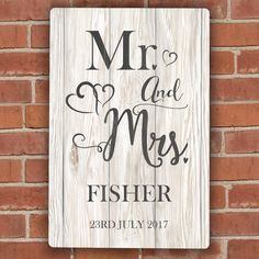 a wooden sign with the words mr and mrs fisher on it hanging on a brick wall