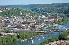 an aerial view of a city with boats on the water and bridge in the foreground