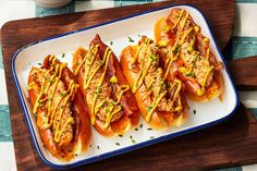 hot dogs with toppings sit on a serving tray