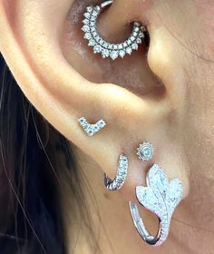 a woman wearing three different ear piercings