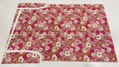 a piece of fabric with pink and white flowers on it, next to a pair of scissors