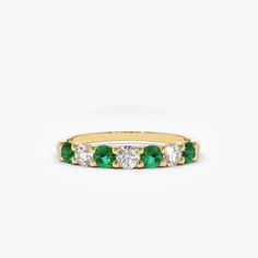 a yellow gold band with emeralds and diamonds