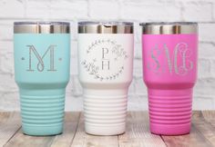 three monogrammed tumblers sitting on top of a wooden table