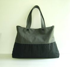 a black and grey bag sitting on top of a table next to a white wall