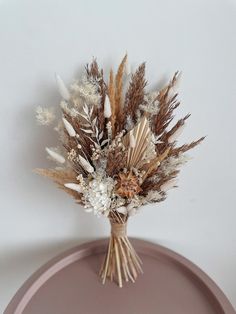 dried flowers in a vase sitting on a table