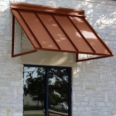 an awning on the side of a white brick building