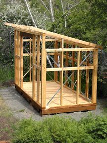 a small wooden structure sitting in the middle of a forest