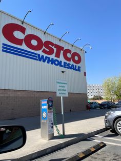 a costco store with a car parked next to it and a parking meter in front