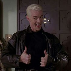 a man in a leather jacket giving the thumbs up