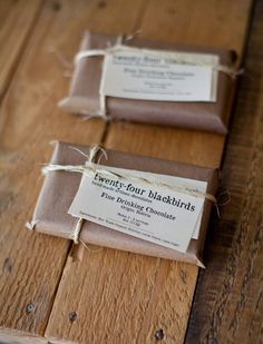 two brown packages tied with twine sitting on top of a wooden table