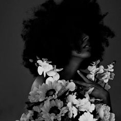 a black and white photo of a woman with flowers in her hair