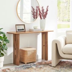 a living room with a couch, mirror and vase on the table in front of it