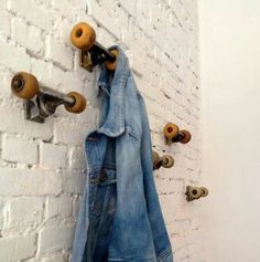 an old pair of jeans hanging on a brick wall with skateboards attached to it