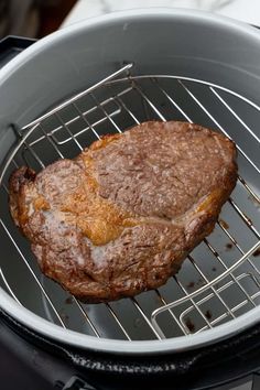 a steak is cooking on the grill in an open pot with it's side being grilled