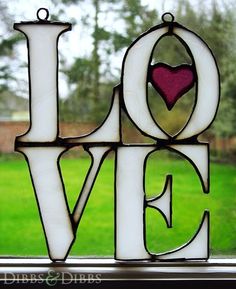 a stained glass window with the word love written in it and a heart on top