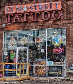 the front of a tattoo shop with large windows