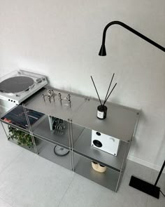 a table with some electronics on it and a lamp in the corner next to it