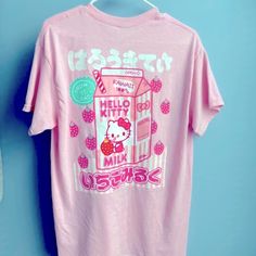 a pink hello kitty t - shirt hanging on a blue wall