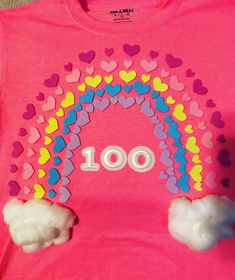 a pink t - shirt with hearts and a rainbow on the front that says 100