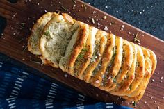 a loaf of garlic bread on a cutting board with salt and pepper sprinkles