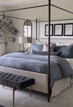 a bed room with a neatly made bed next to a window and a chandelier