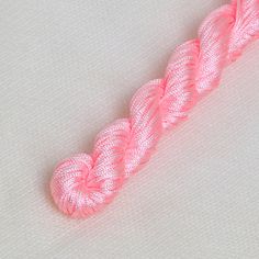 the pink thread is being used to make an ornament