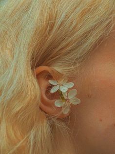 a close up of a person's ear with flowers in the middle of it