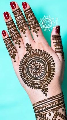 a woman's hand with henna tattoos on it