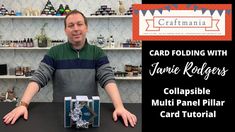 a man sitting at a table in front of a card folding with jamie ridgers collapsible multi panel pillar card