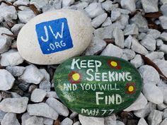 two rocks with words painted on them sitting in the gravel next to some rocks that say keep seeing and you'll find