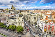 an aerial view of buildings and traffic on a street in the center of madrid, spain