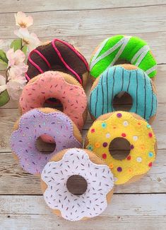 six donuts with sprinkles on them sitting next to a bouquet of flowers