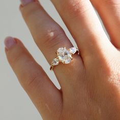 a woman's hand with a three stone ring on it