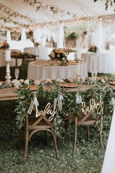 the chairs are decorated with greenery and wooden signs that read happily married on them