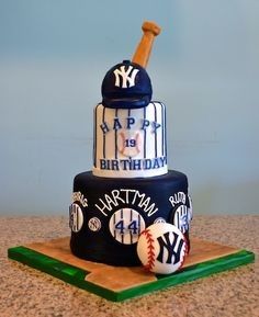 a three tiered birthday cake with baseballs and bats on the top, sitting on a table