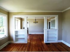 an empty living room with hard wood floors