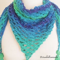 a blue and green crocheted scarf with tassels