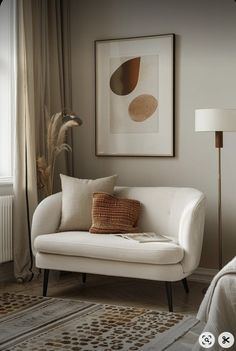 a white couch sitting next to a window in a living room on top of a rug