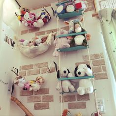 several stuffed animals are hanging on the brick wall in this children's playroom