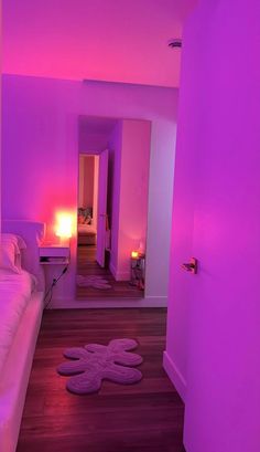 a bed room with a neatly made bed and purple lighting