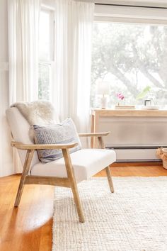 a white chair sitting in front of a window