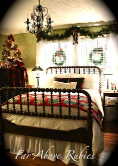 a bedroom decorated for christmas with a bed, chandelier and plaid blanket on it