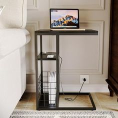 a laptop computer sitting on top of a wooden table next to a white couch in a living room