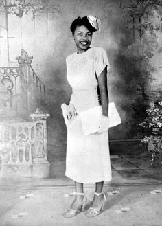 an old black and white photo of a woman in a short dress with a hat on her head