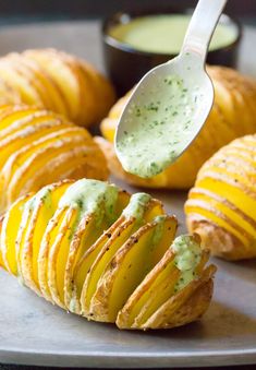 baked potato wedges on a plate with dip in the middle and dipping sauce over them