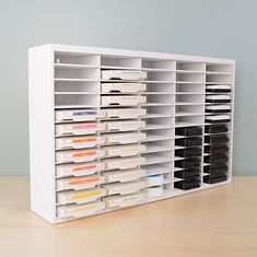 a large white shelf with many files and folders in it on a wooden table